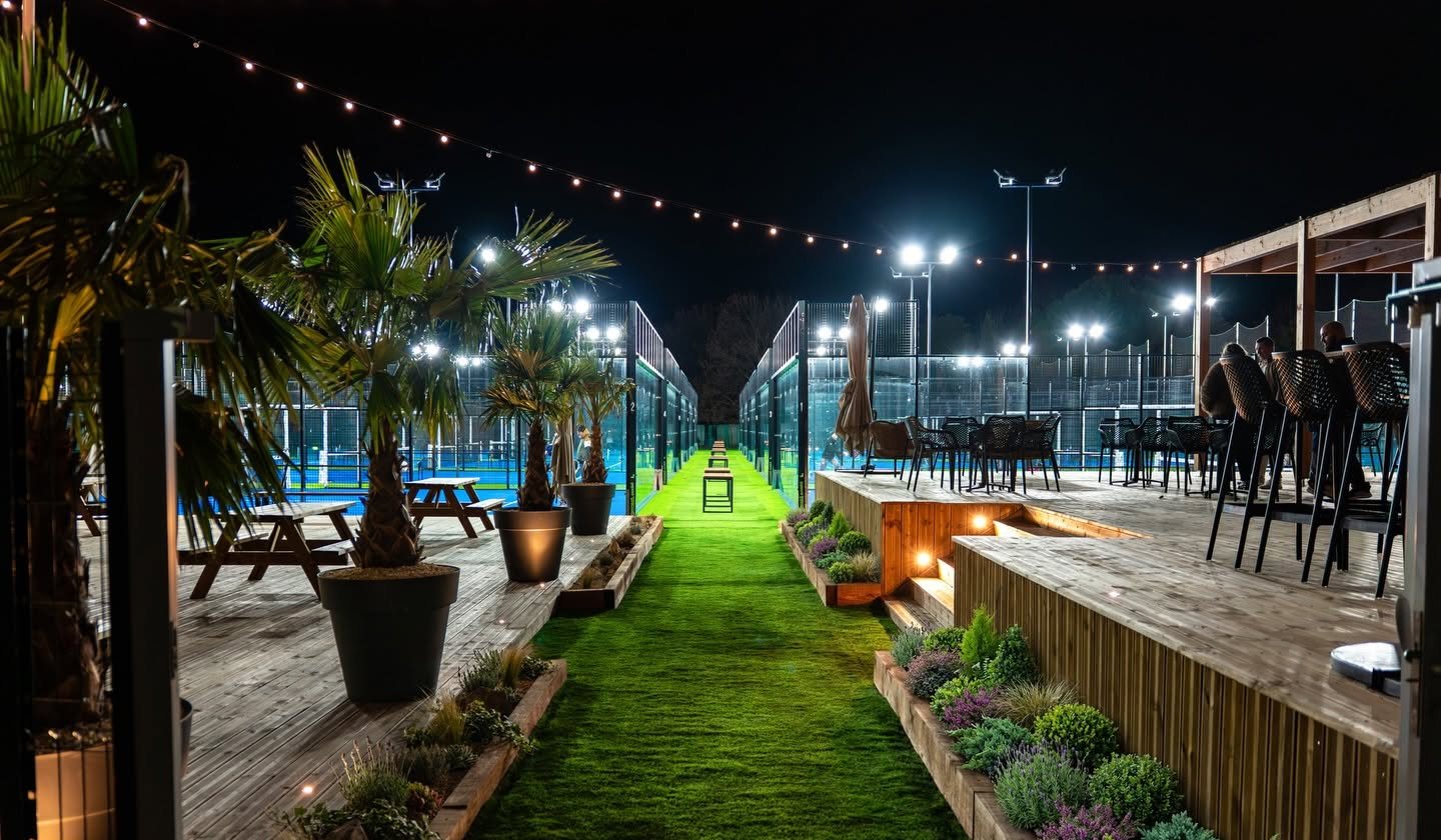 Le club Padel Performance Center au Parc Praden de nuit : terrasses, palmiers et terrains illuminés